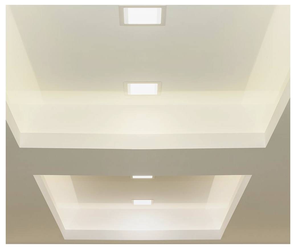 Recessed ceiling lights arranged in two squares with warm illumination, creating a layered, modern design.