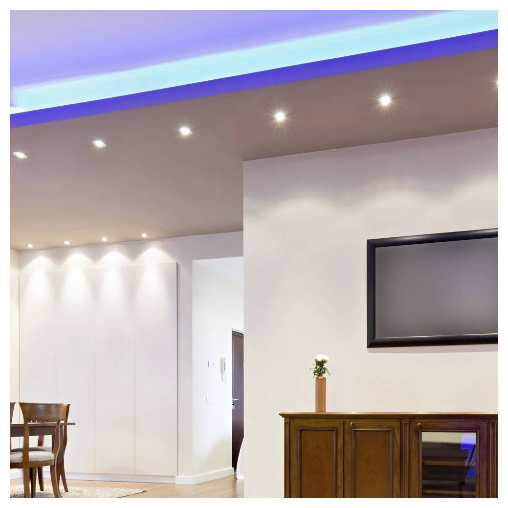 A modern living room with recessed ceiling lights, a wall-mounted TV, and a small cabinet. The room has a minimalist design and bright lighting.