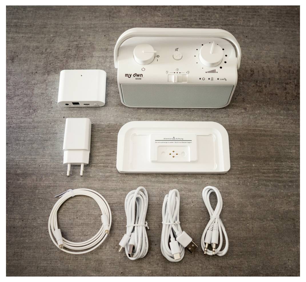 'My Own Solar Sound System' with charger, cables, and accessories on a gray surface.