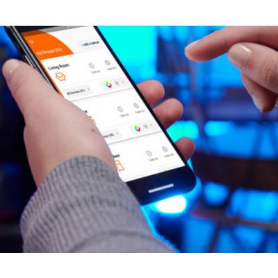 'Person controlling smart home devices using a smartphone app, viewed close-up. Screen shows options for lighting and temperature adjustments.'