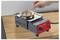 'A hand holding a wire is dipping it into a small electric solder pot on a wooden table. The pot is set to 200 degrees Celsius.'
