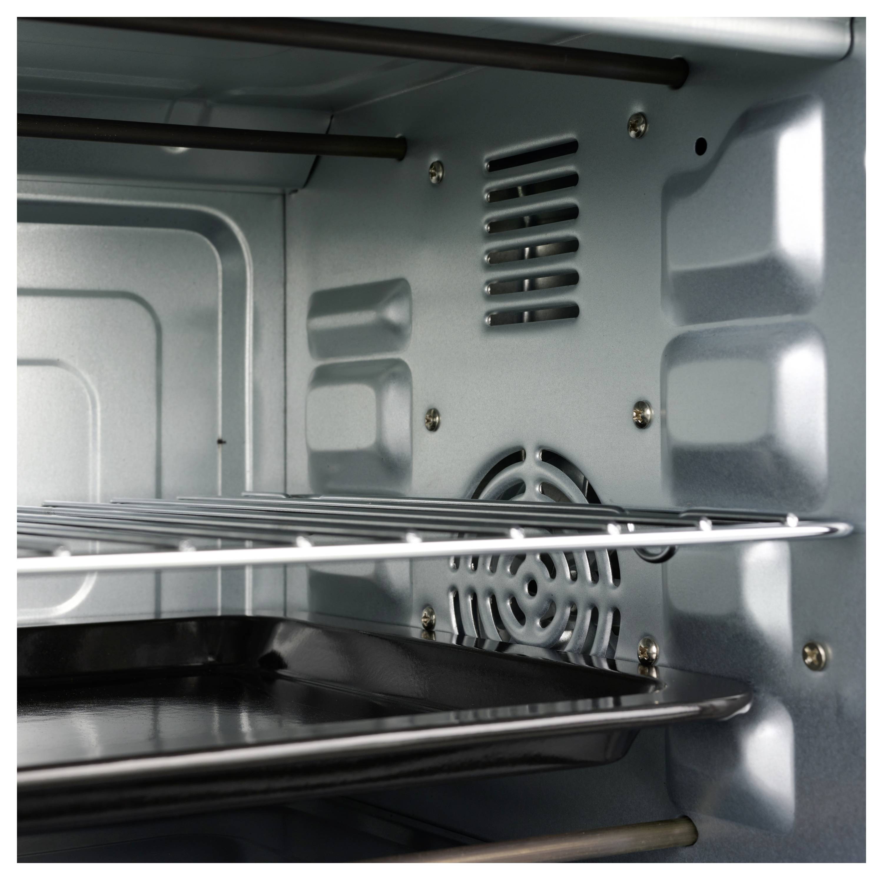 Inside view of an oven showing metal racks and a fan at the back for convection heating. The interior is metallic gray and clean.
