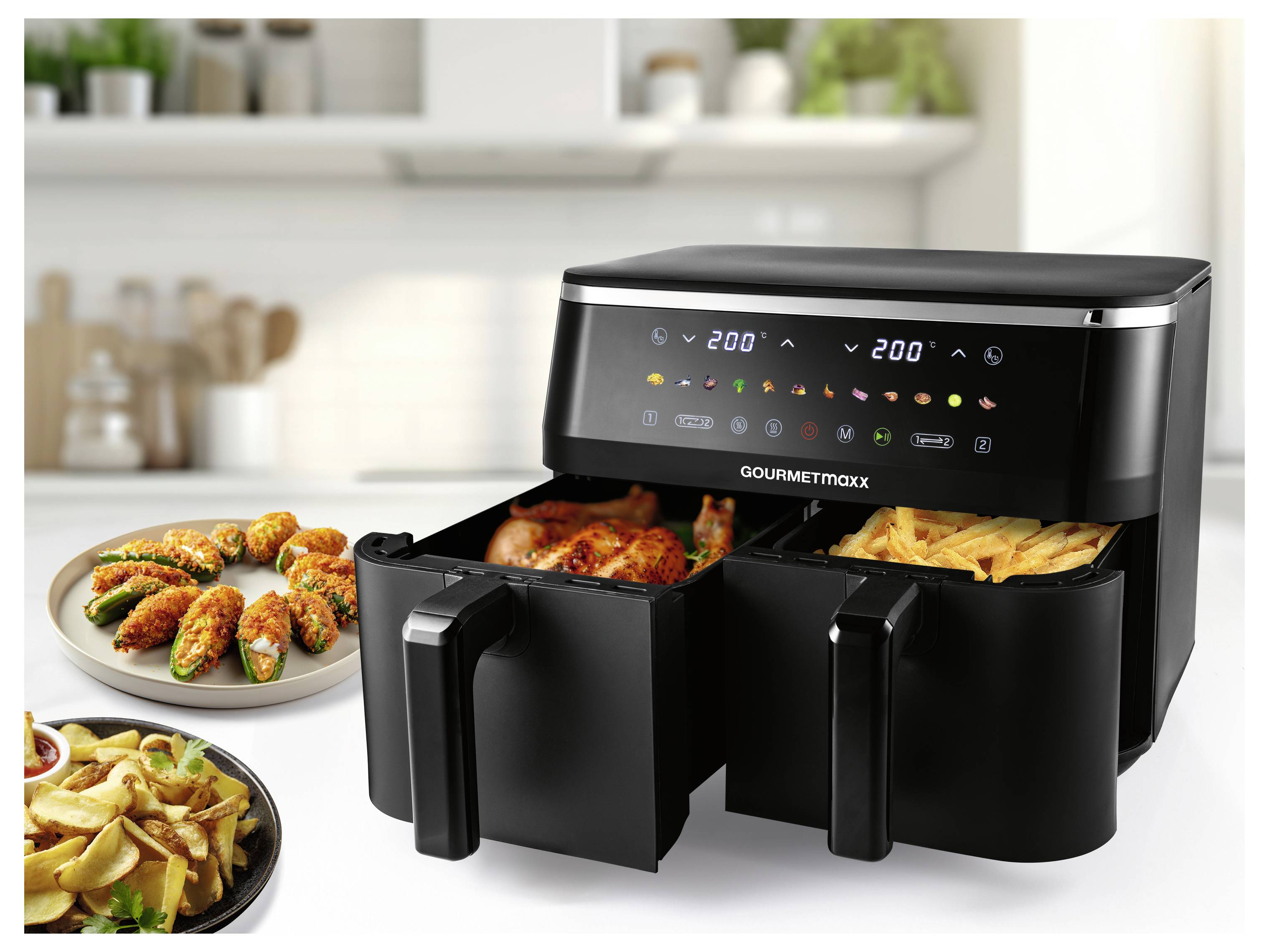 A kitchen setting with a double-basket air fryer cooking chicken and fries, alongside plates of fried appetizers, illustrating its versatility.