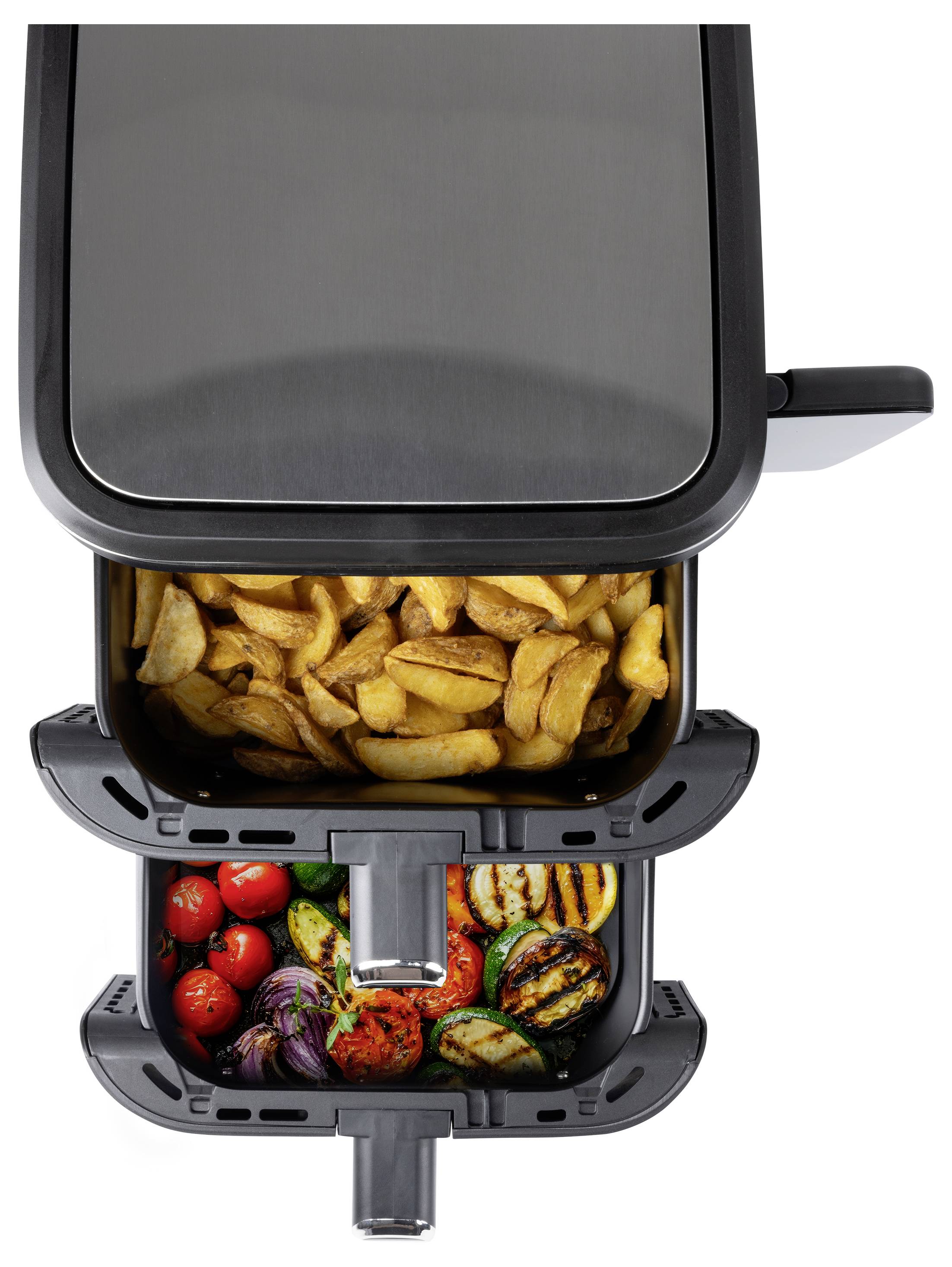 An open air fryer with cooked potato wedges in the top basket and a variety of grilled vegetables, including tomatoes and zucchini, in the bottom basket.