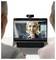 Two people participate in a video call on a laptop. A woman on the screen is speaking, and a webcam is attached to the laptop.