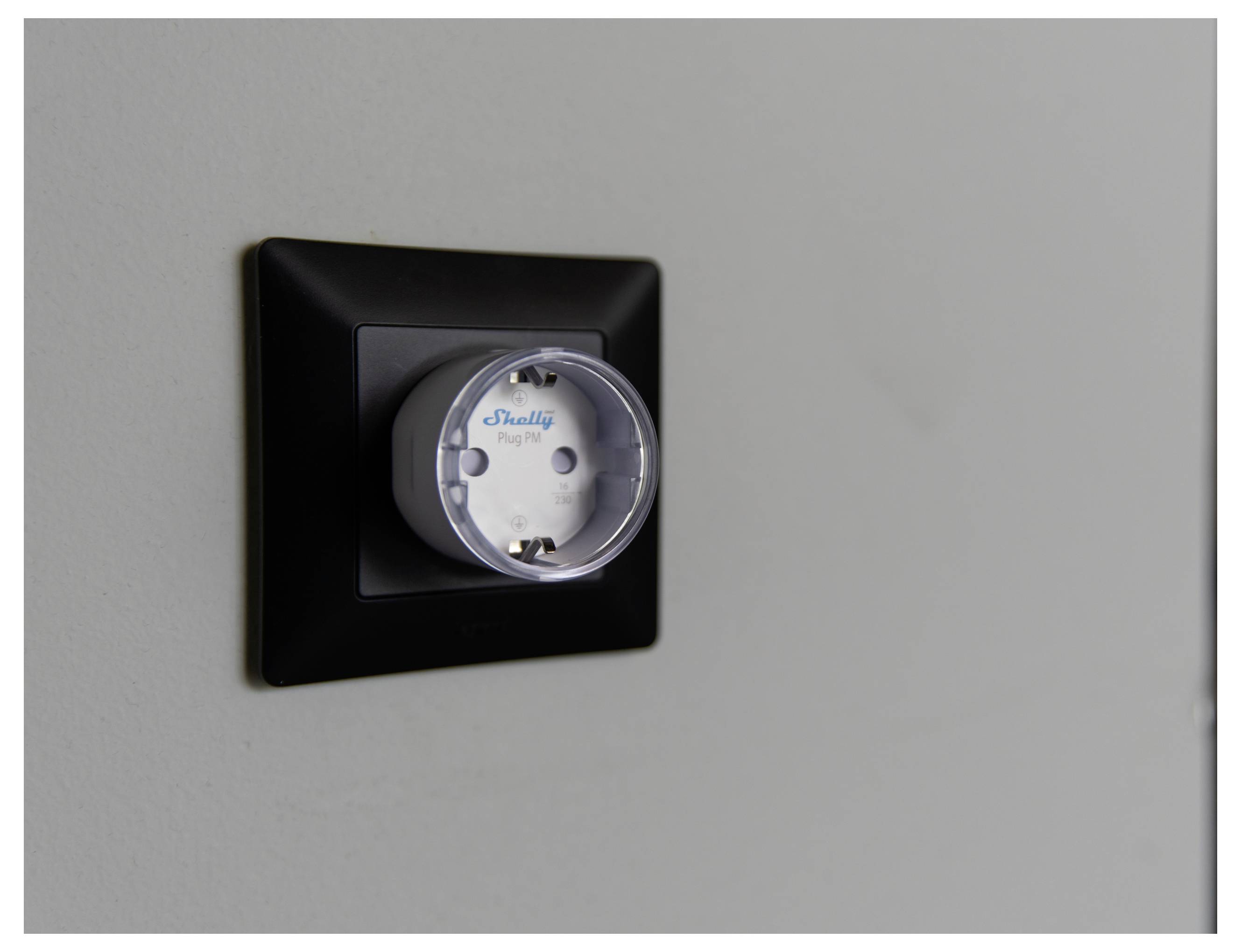 'A Shelly Plug device inserted into a black wall socket.'
