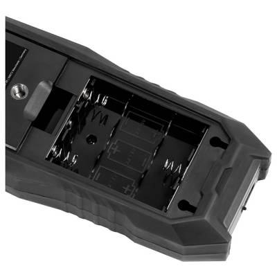 Open black battery compartment with metal springs and molded slots inside a handheld device or tool.