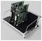 Two green circuit boards mounted upright in a metal cooling or electronics rack with black fins and side handles.