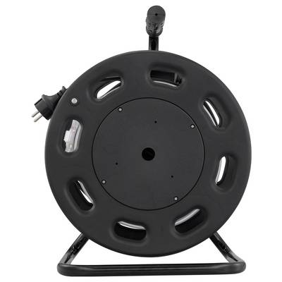 Black retractable extension cord reel with power plug, front view on a stand, showing the coiled cord housing and outlet indicator window.