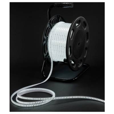 Spool of flexible LED strip light glowing white on a black reel against a dark background, with the strip uncoiled in front.