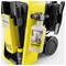 Yellow Kärcher K5 pressure washer with attached Universal Cleaner bottle, a hose reel, and a nozzle holder.