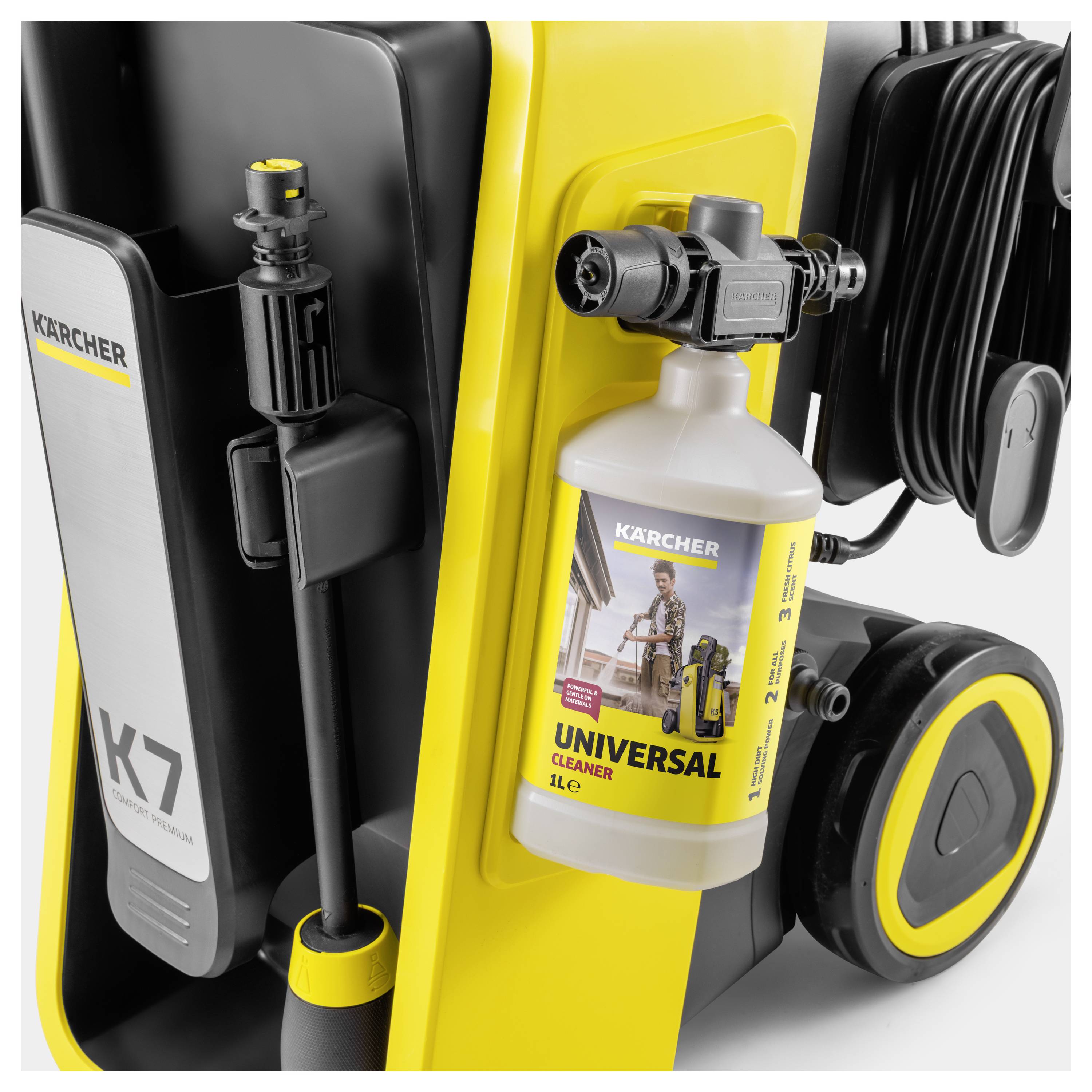 'Close-up of a Kärcher pressure washer with a labeled bottle of universal cleaner attached, showing part of the hose and handle.'