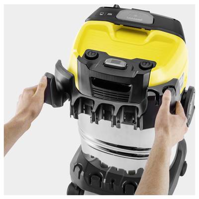 'Hands attaching side clips to a yellow and silver wet-dry vacuum cleaner.'