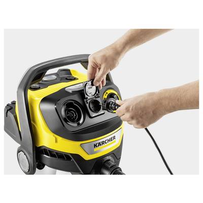 Hands connecting a cable to a yellow and black Kärcher cleaning machine, focusing on a detailed view of the front panel and interface.