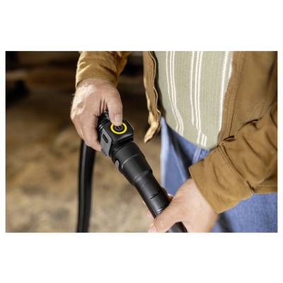 Person connecting a vacuum hose attachment, focusing on the hands and device, suggesting preparation for cleaning tasks.