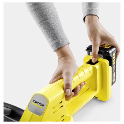 A person inserts a battery into a yellow Kärcher device, highlighting the ease of use and functionality of the cordless tool.