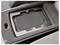 Black wireless charging pad recessed in a car center console foam insert, with a target icon on the charging surface.