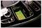 Car center console with a smartphone displaying 'INBABY', placed in a wireless charging compartment next to climate and control buttons.