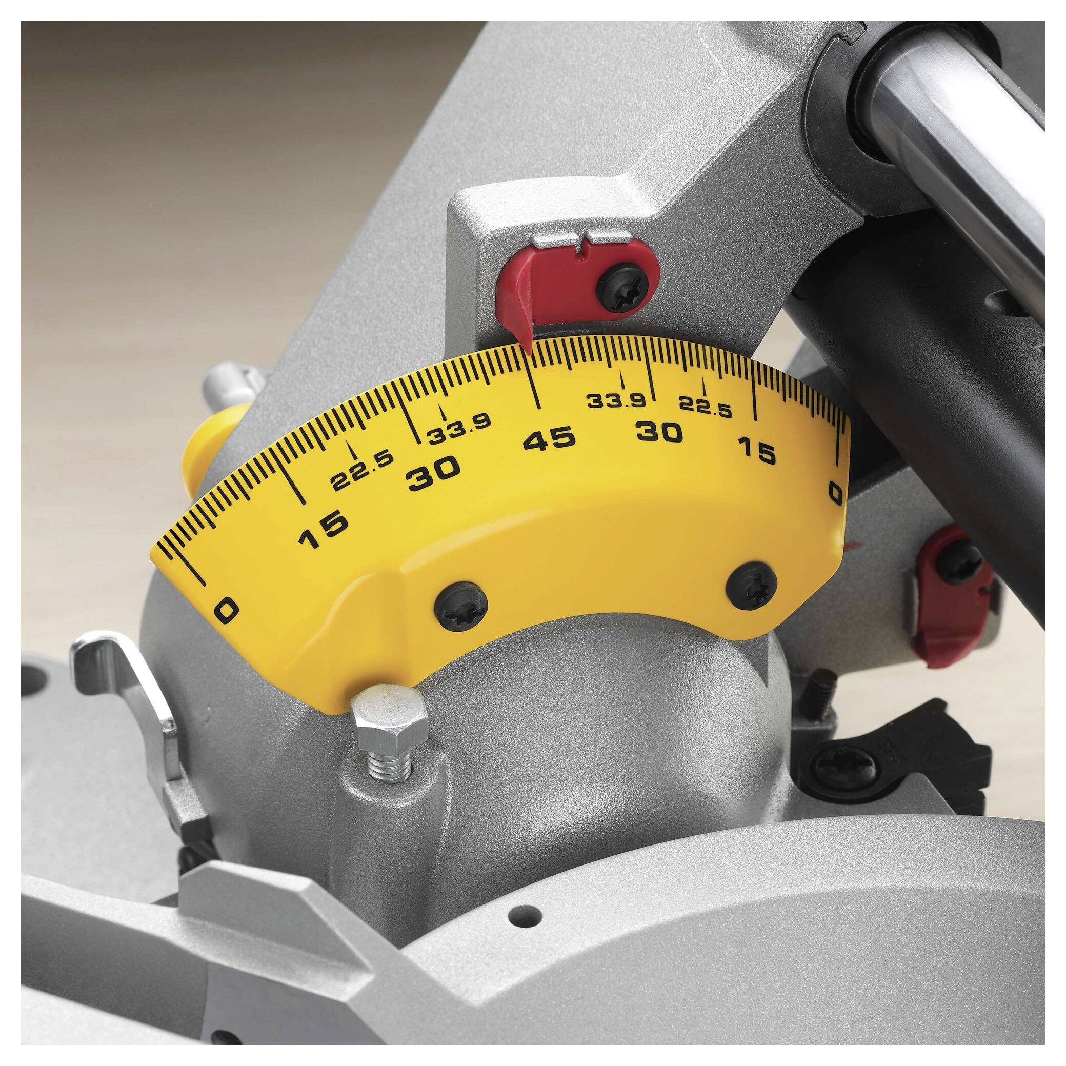 A close-up of a miter saw's angle adjustment gauge showing a yellow dial set to 33.9 degrees, with a silver base and red knobs.