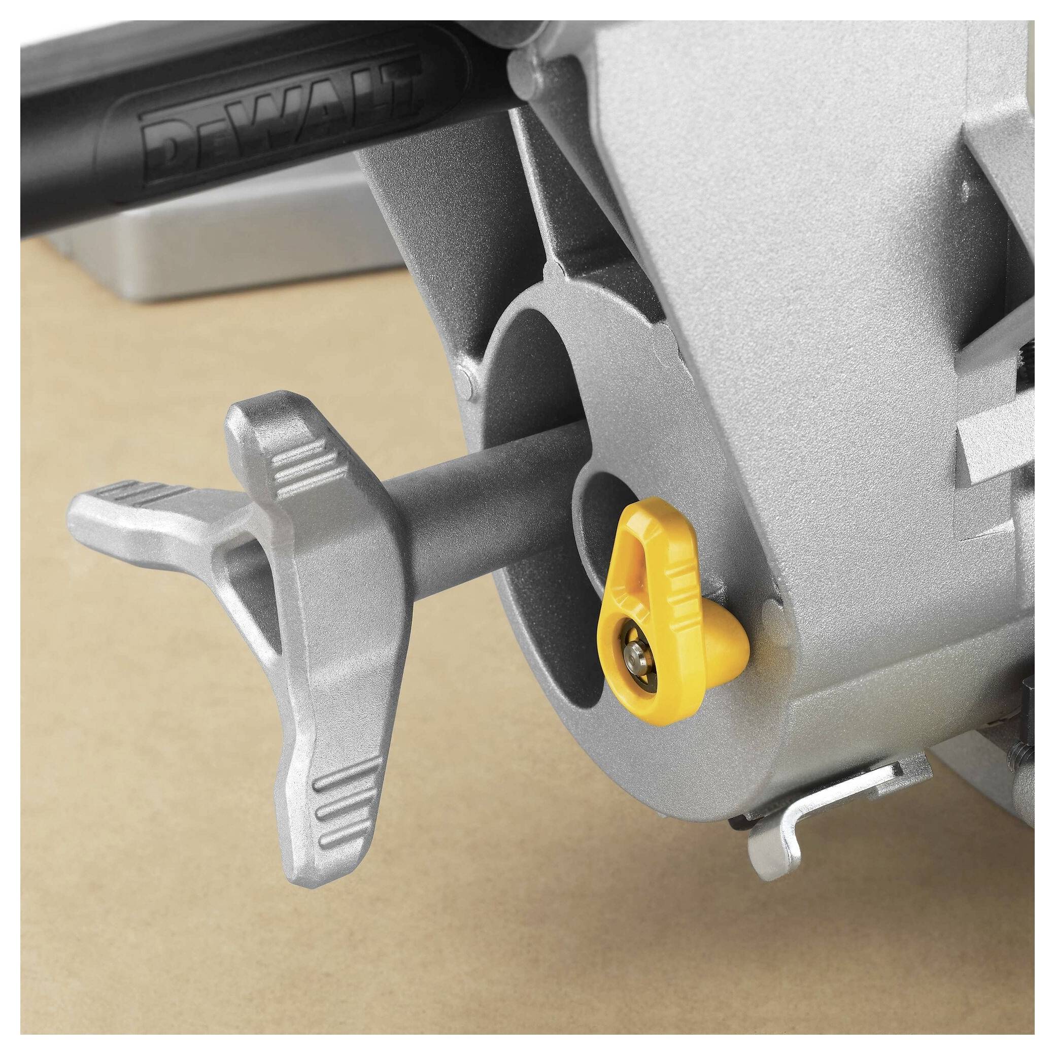 A close-up of a power tool's adjustment mechanism, featuring a metal lever and a yellow button against a metallic gray surface.