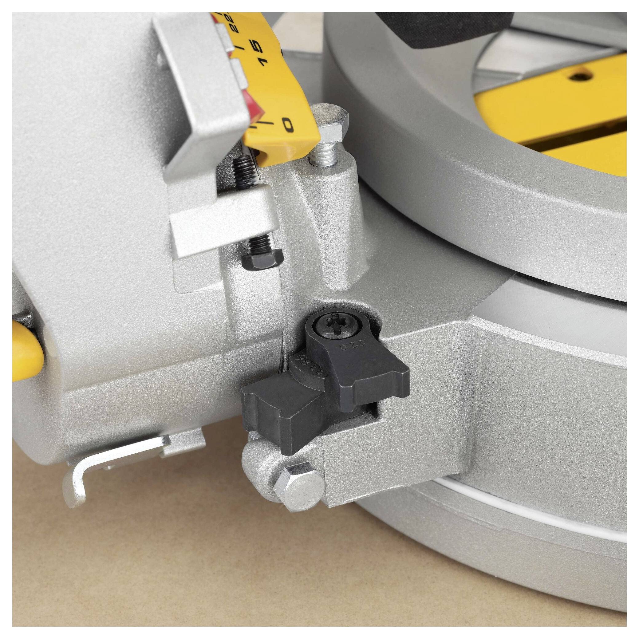A close-up of a silver circular saw base showing adjustment knobs and a yellow angle scale for precise angle cutting.