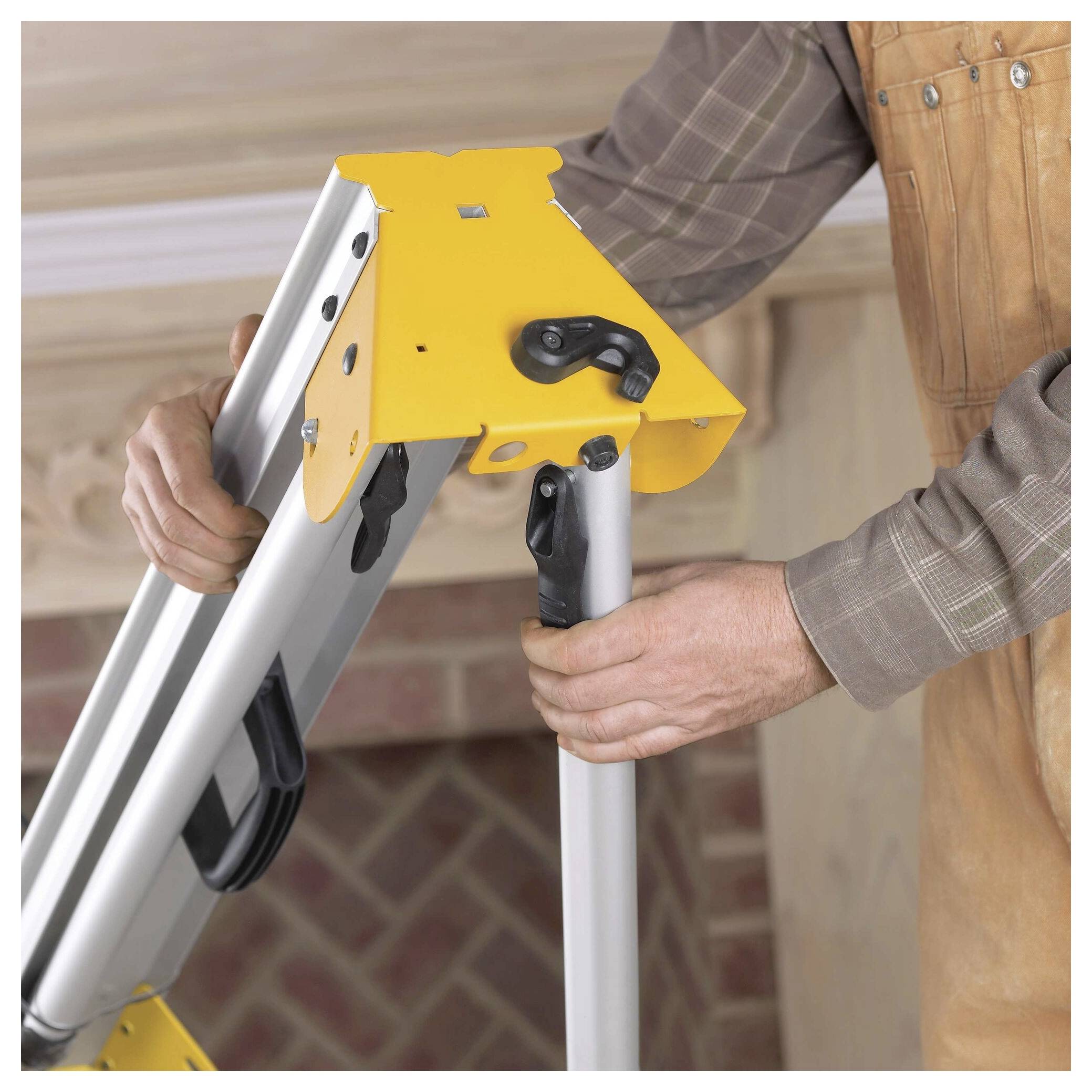 'Person adjusting a yellow metal clamp on a silver ladder, wearing a brown shirt and apron, set against a brick-patterned background.'