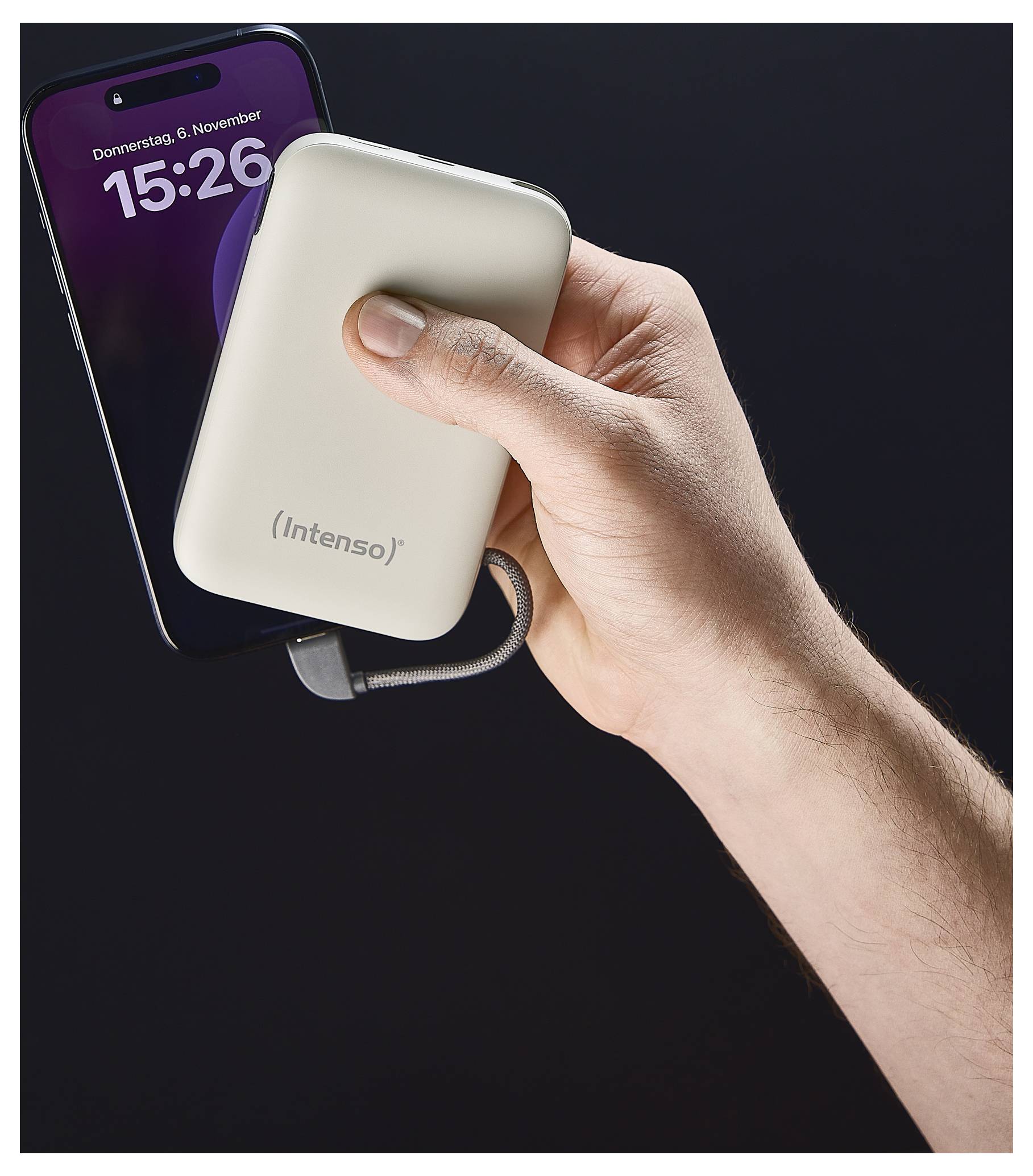 A hand holds a smartphone connected to an Intenso power bank via a cable. The phone displays the time as 15:26 on a Thursday.
