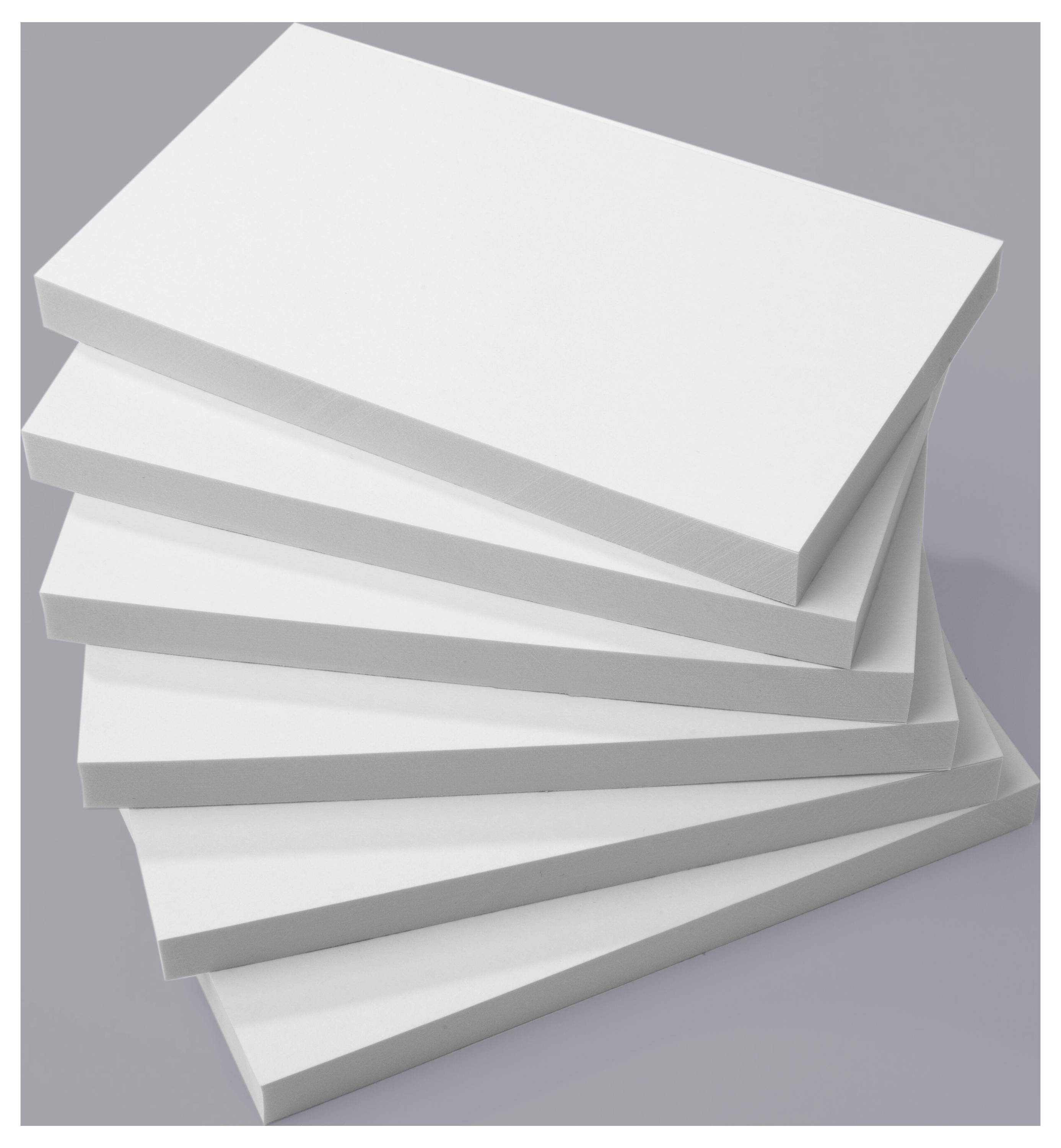 A stack of six blank white rectangular sheets arranged in a staggered manner on a gray surface.