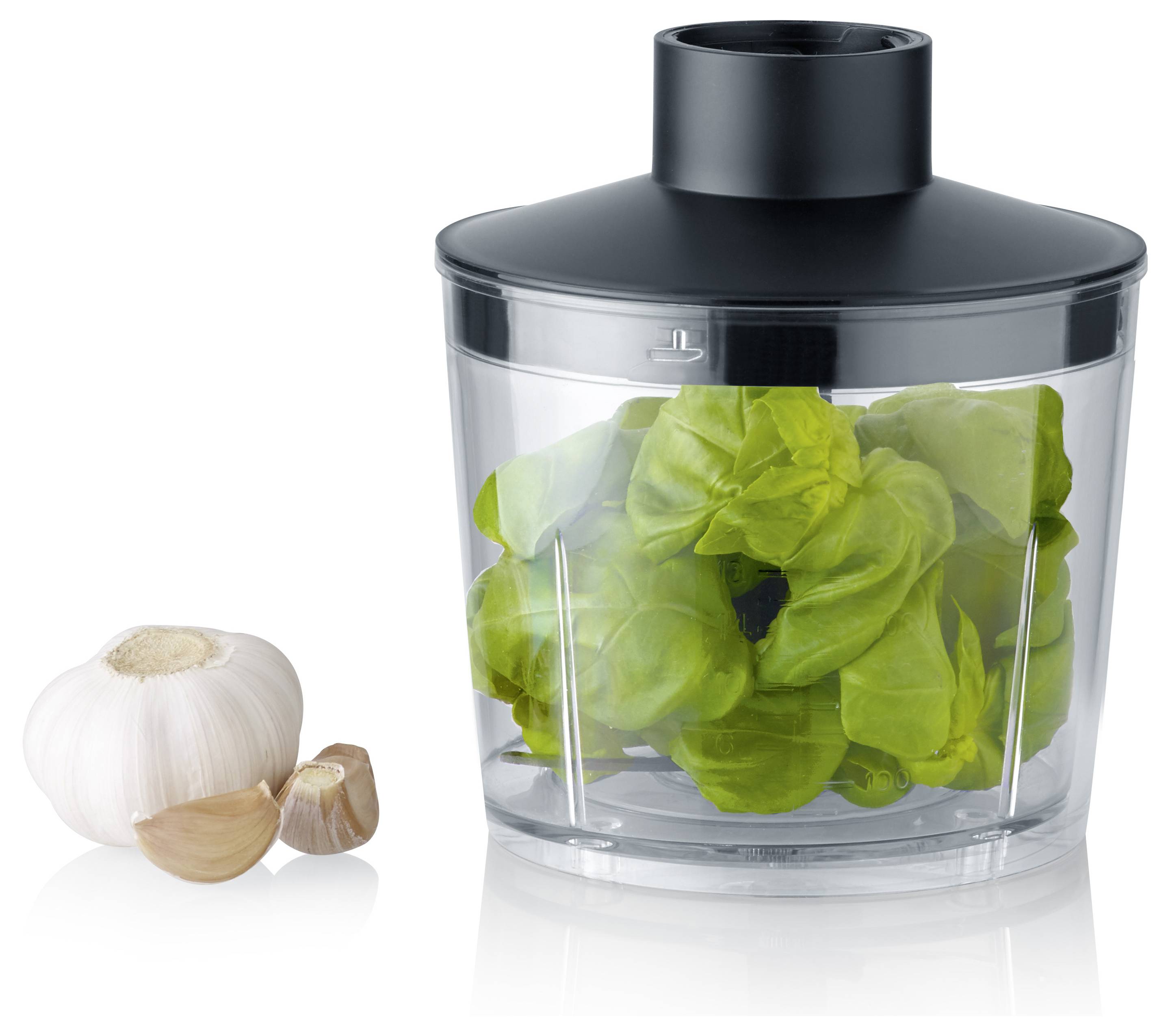 A garlic bulb and cloves sit beside a plastic container filled with fresh basil leaves, covered by a black lid, suggesting food preparation.