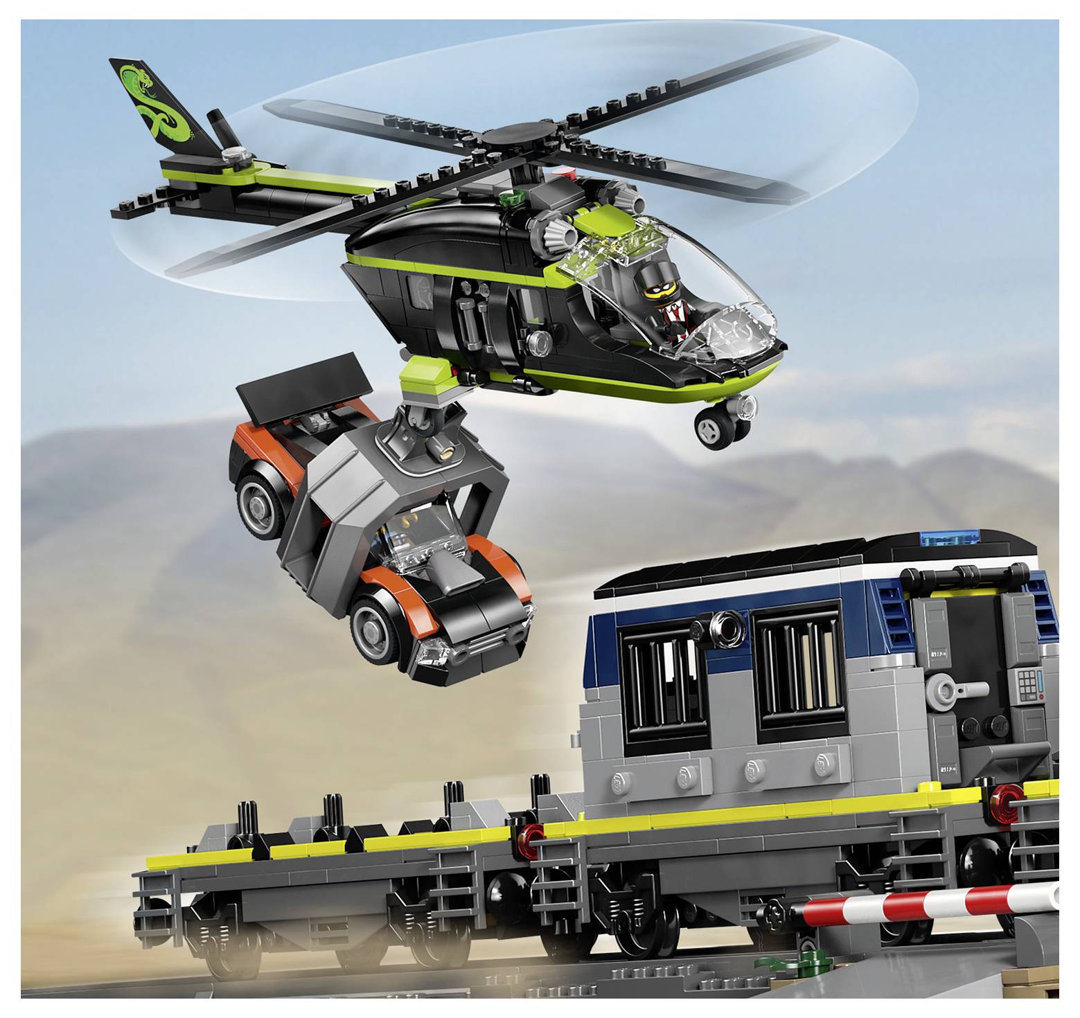 A toy helicopter hovers over a train, carrying a small vehicle. The train is on a track. The scene is set against a blue sky.