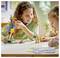 Children playing with colorful building blocks, creating a bird and a dinosaur, smiling and engaged in imaginative play at a table.