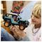 A person smiles while holding a detailed toy Jeep with bright orange wheels, showcasing its realistic design and intricate assembly.