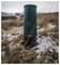 Portable coffee maker standing upright in a snowy, grassy outdoor landscape, highlighting its compact design and rugged use capability.