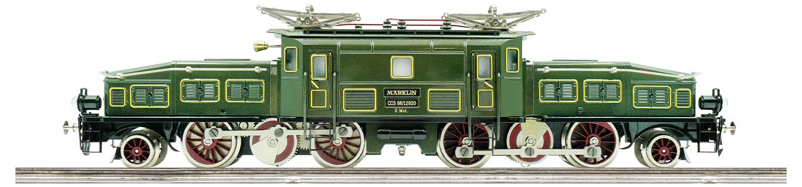 A detailed model of a vintage green electric train engine with red wheels and decorative gold outlines, displayed on a track.