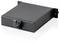 A rectangular black device, likely a computer or network component, with mounting brackets and a front port, sits on a reflective surface.