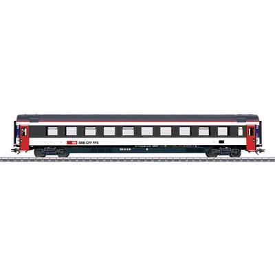 A Swiss train passenger car with red and white design, labeled 'SBB CFF FFS', stands on the track, showcasing multiple windows.