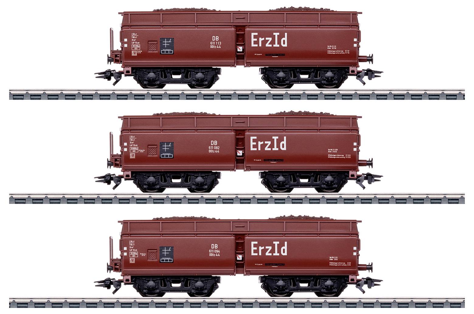 Three brown freight train cars labeled 'ErzId', each filled with cargo, are aligned on parallel tracks against a white background.