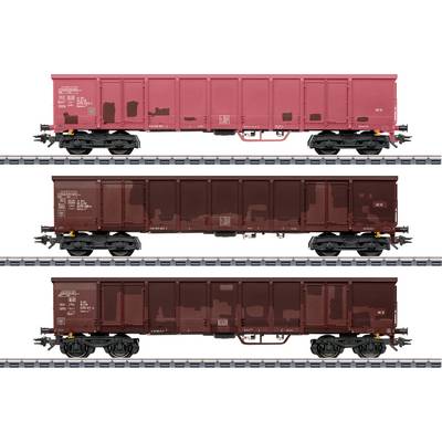 Three side views of model freight train cars on tracks; top car is red, middle and bottom cars are dark brown, all with white text.