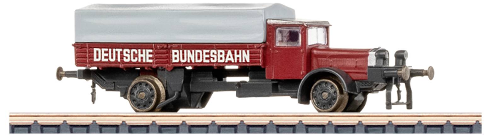 A model train car with a red body, marked 'Deutsche Bundesbahn,' and a grey roof is displayed on train tracks.