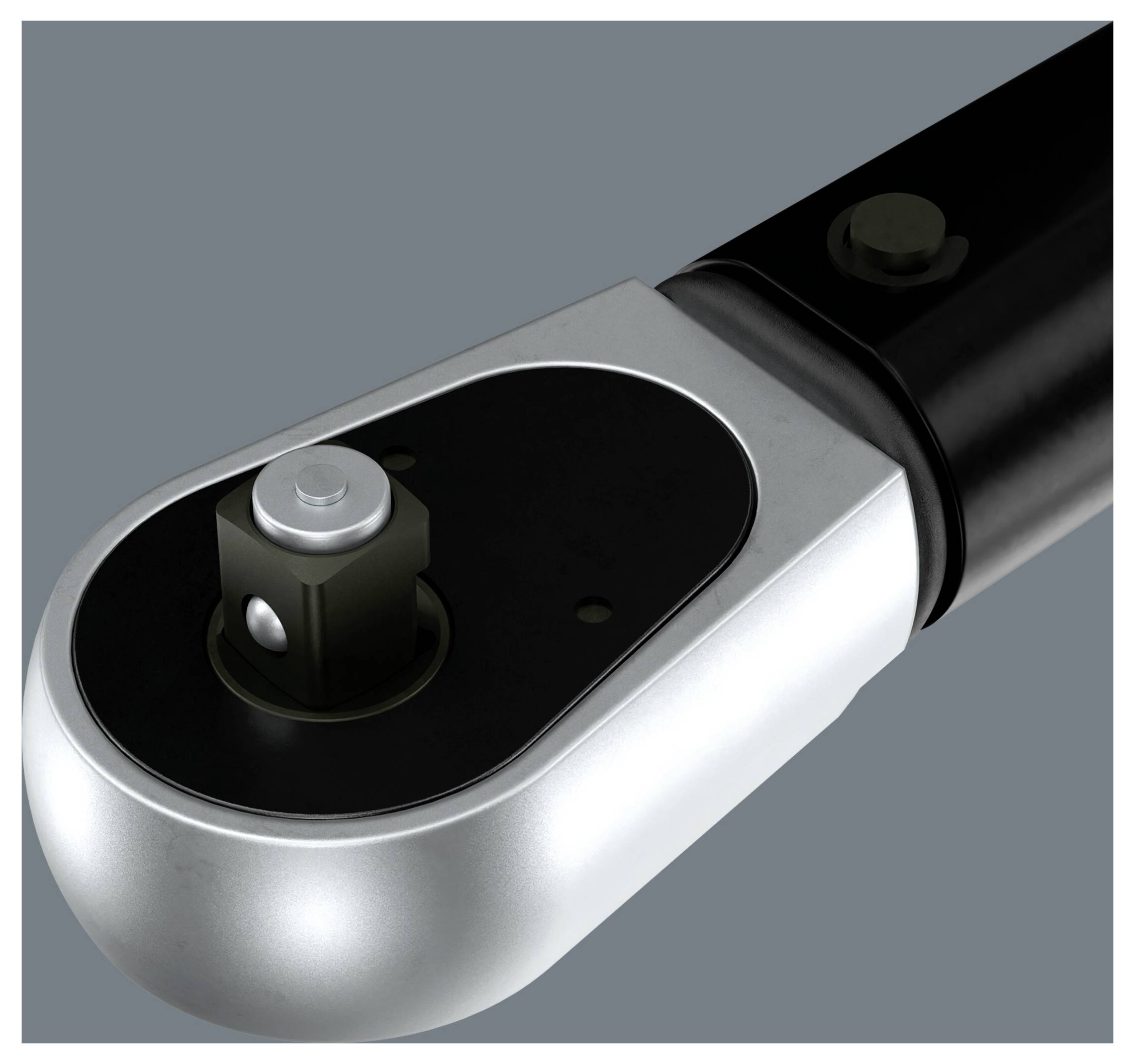 A close-up view of a metallic ratchet head with a circular design, featuring a square drive socket. The handle is black.