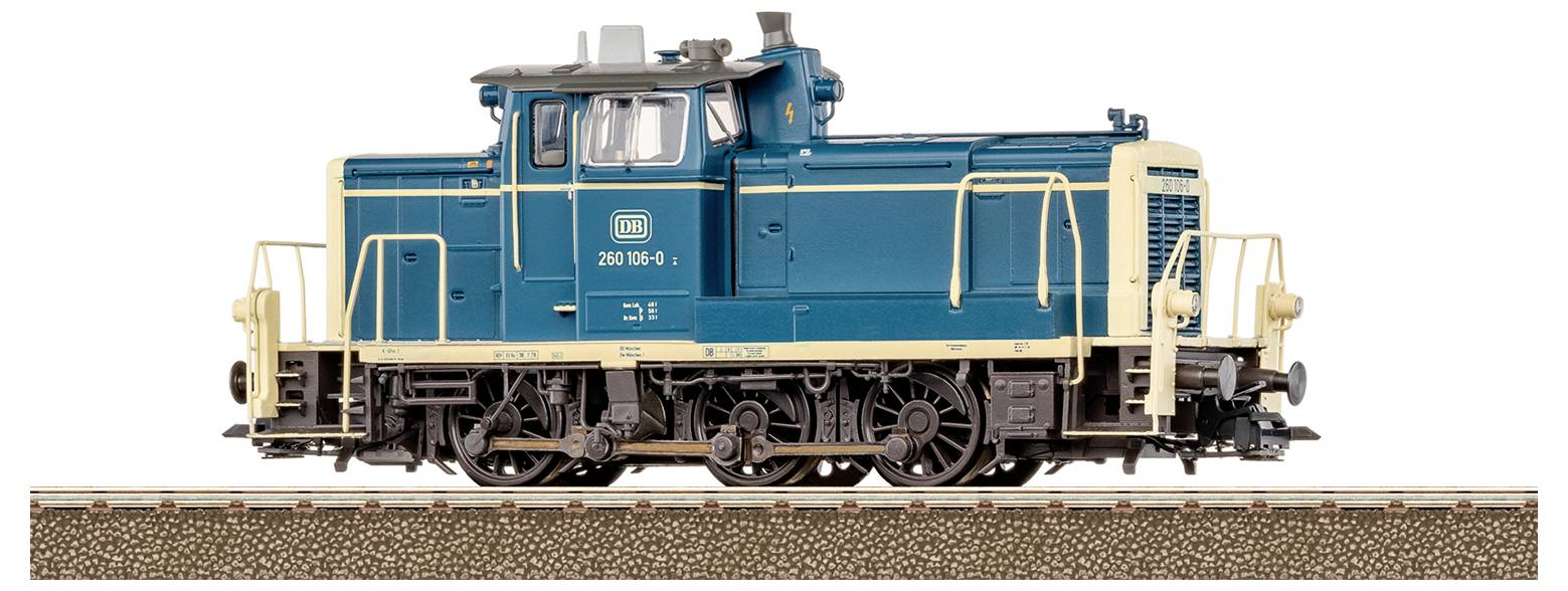 A blue and beige model train locomotive sits on a track. It features detailed wheels and railings, marked with '360 594-1'.