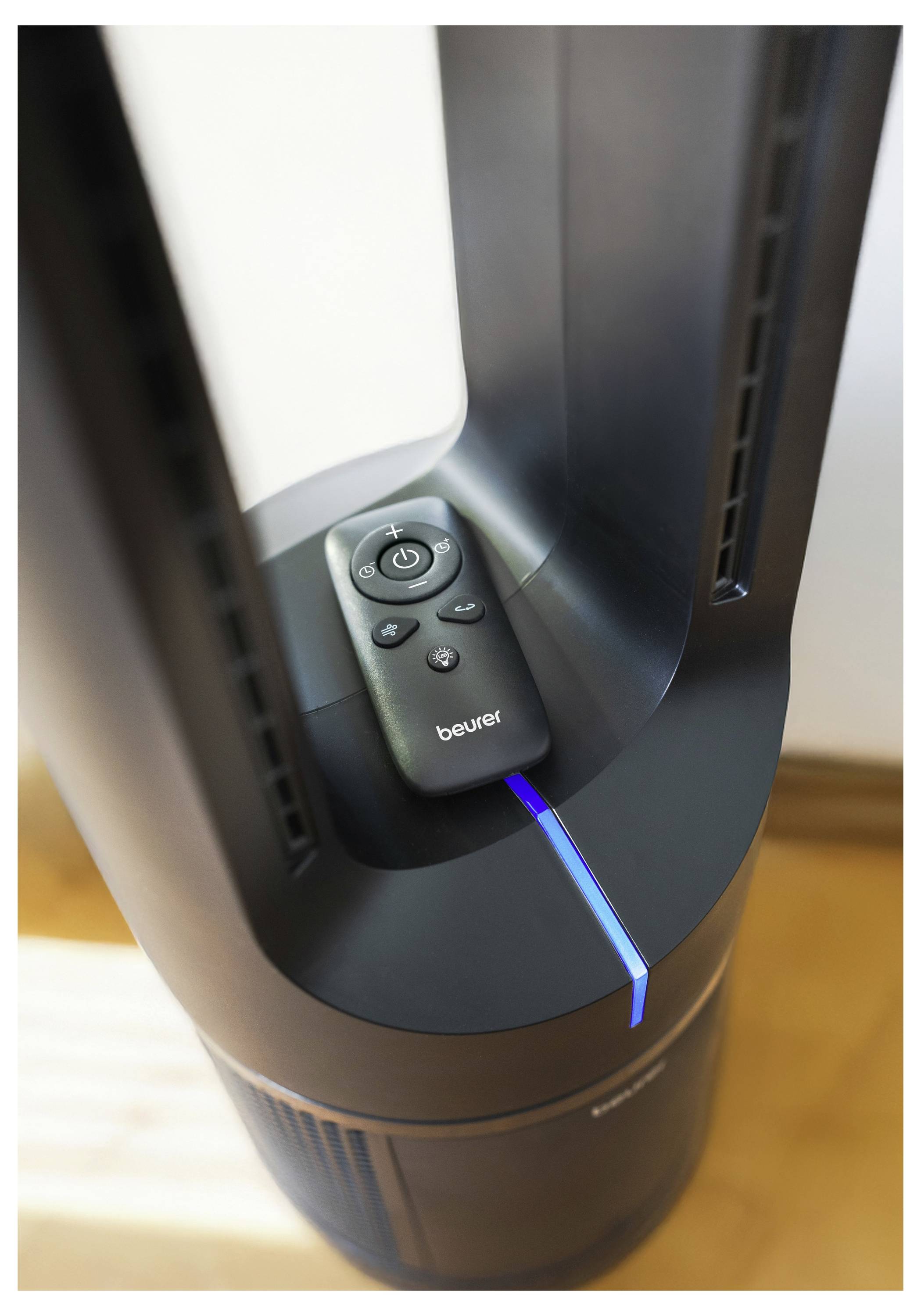 A bladeless fan with a remote control resting on top, featuring a blue LED indicator light on the base; sunlight casts a shadow.