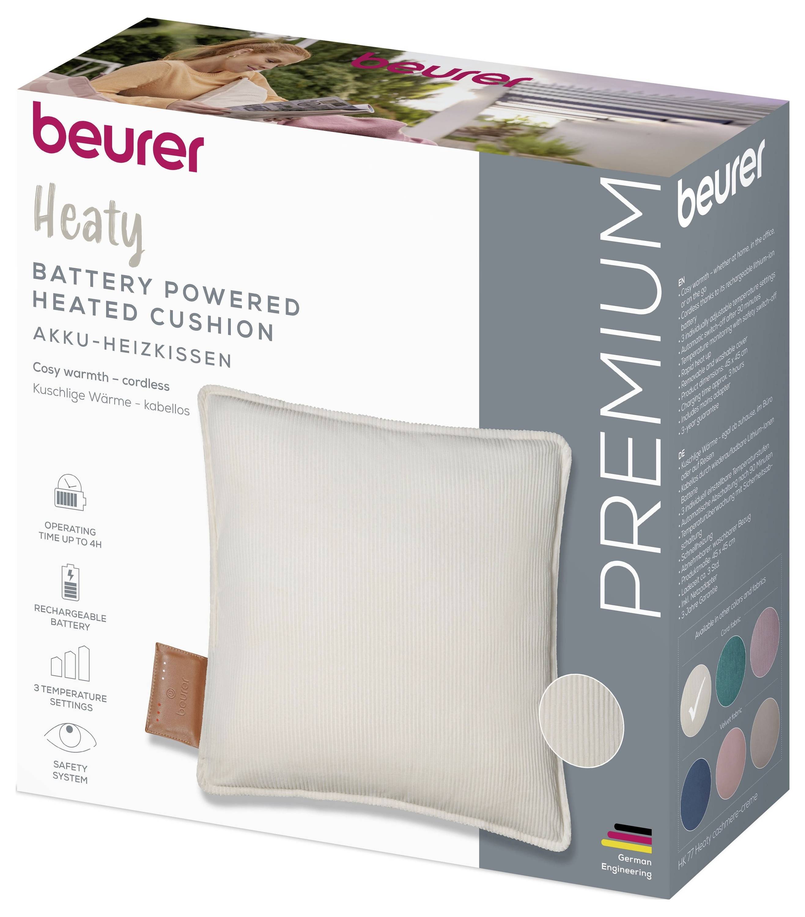 'Beurer Premium battery powered heated cushion' packaging showing a soft cushion design, color options, and features like cordless use, rechargeable battery, and safety system.