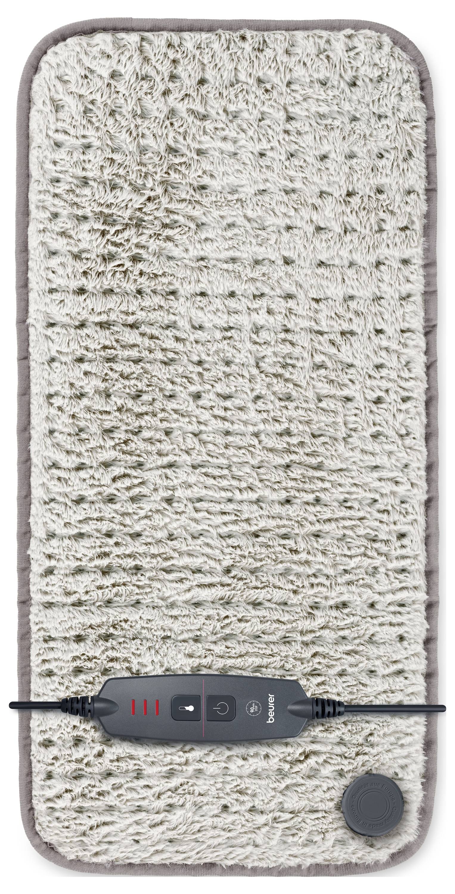 Rectangular textured beige mat with a black control panel and red indicator lights, likely for heating or massage, placed centrally.