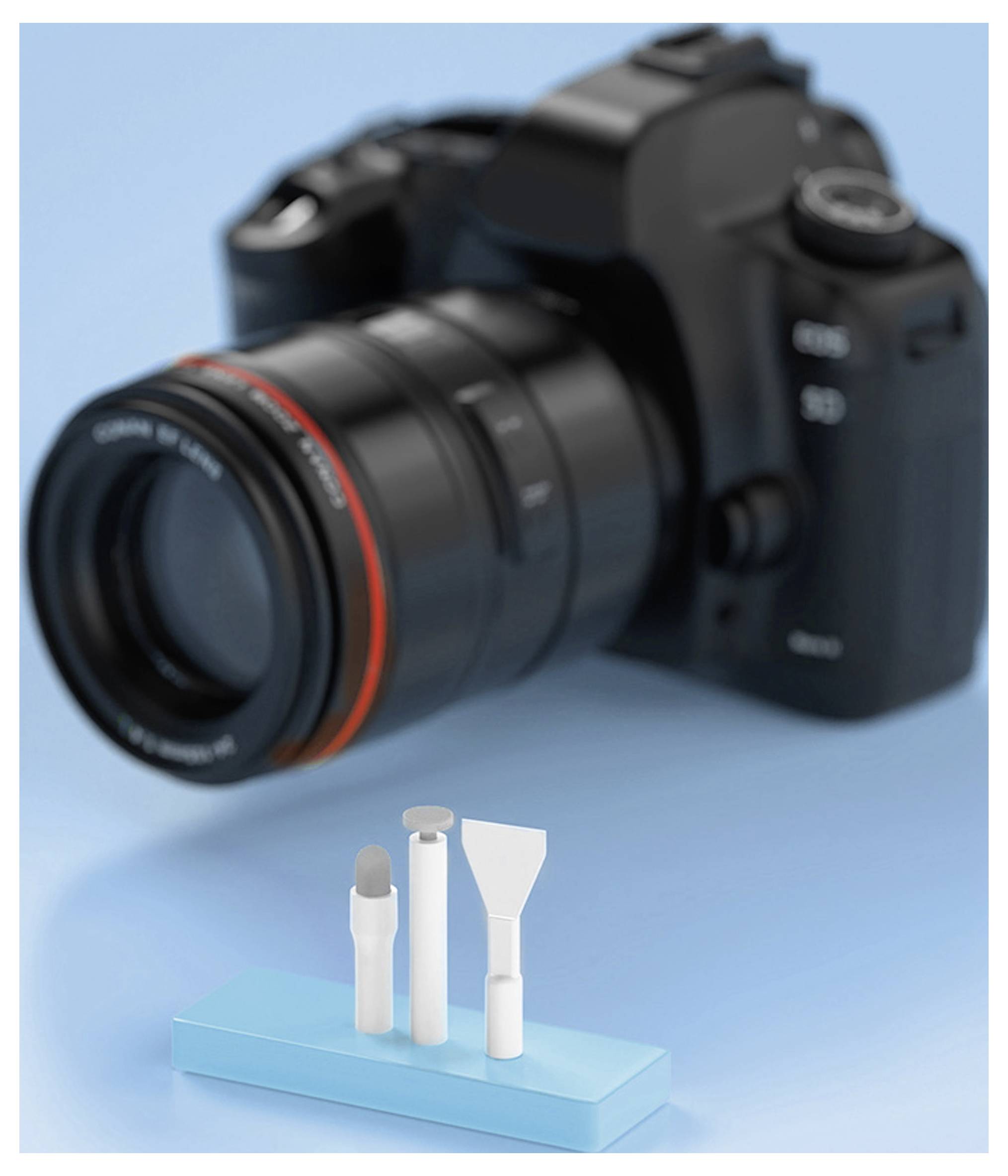A professional camera is out of focus in the background, while a blue stand holds three precision cleaning tools in the foreground.