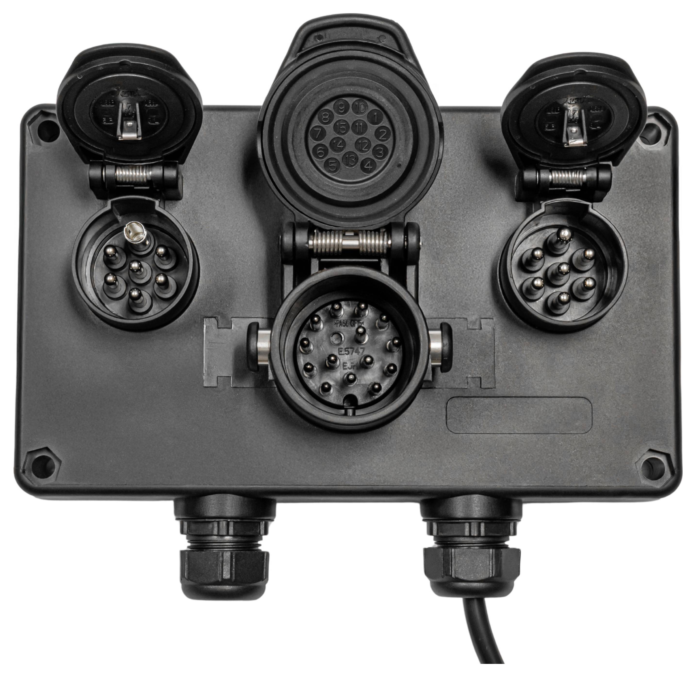 A black electrical connector panel with multiple circular sockets, each covered by a hinged cap, used for interfacing electronic equipment.