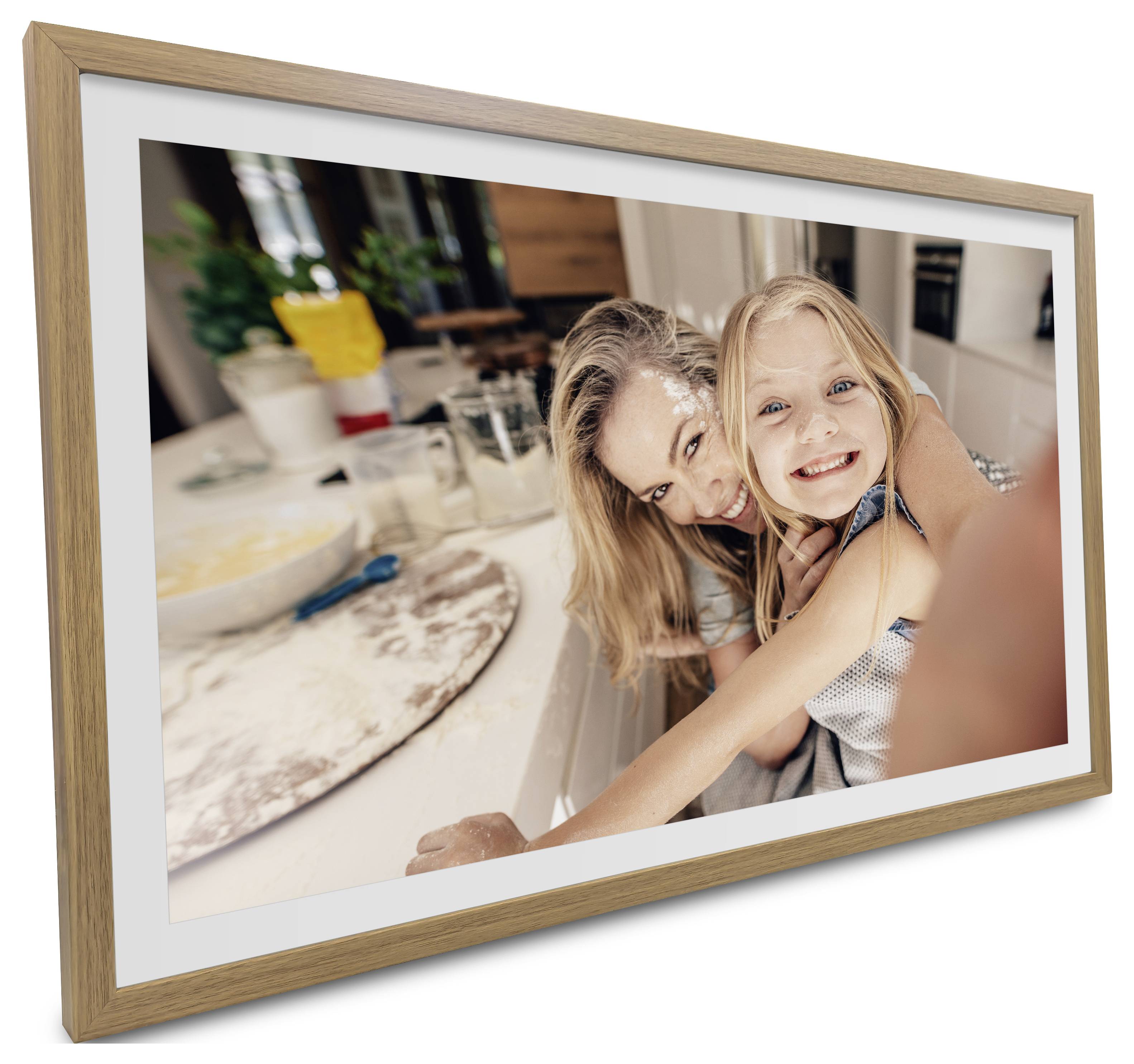 A woman hugs a smiling young girl in a kitchen, with baking ingredients like flour and utensils visible on the counter.