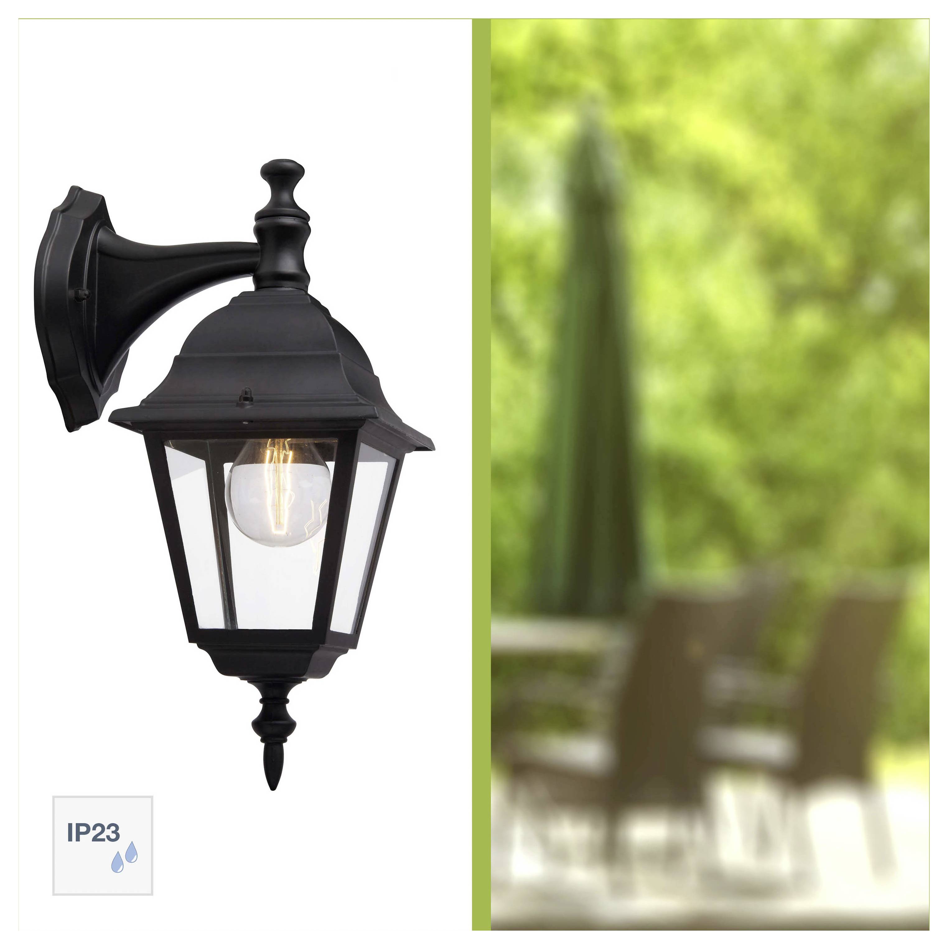 'Black outdoor wall lantern with a bulb inside, mounted on a wall. IP23 rating visible. Patio scene blurred in the background on the right.'