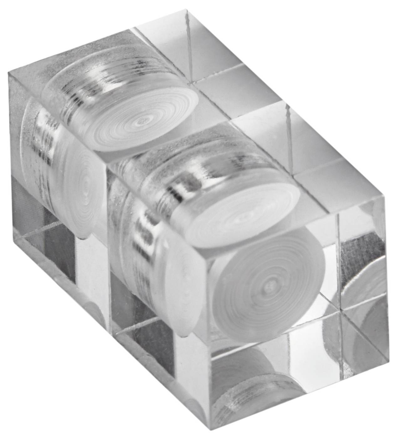 A clear block encapsulating multiple coiled bundles of film, arranged symmetrically, showcasing a unique artistic presentation.