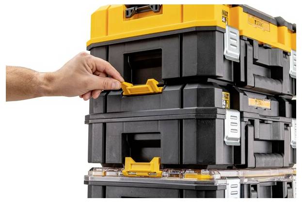 A hand opens a latch on a stack of interlocking black and yellow toolboxes, demonstrating their modular storage design.